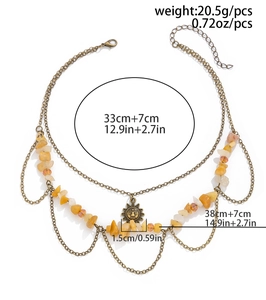 Macro detail of retro layered gold necklace with sun pendant and yellow stone beads