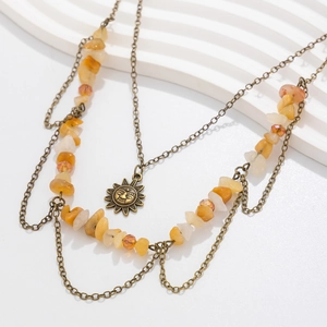 Detail of vintage bronze multi-layer necklace with sun pendant and mixed yellow stones