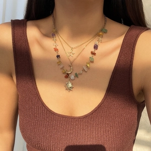Bohemian triple layer gold necklace featuring moon, sun, and star charms with colorful stones