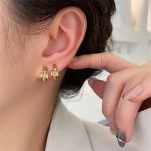 Minimalist gold hoop earrings with rectangular clear zircon worn on ear for women