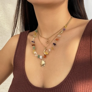 Detailed view of triple-layered necklace with celestial charms and colorful natural stones