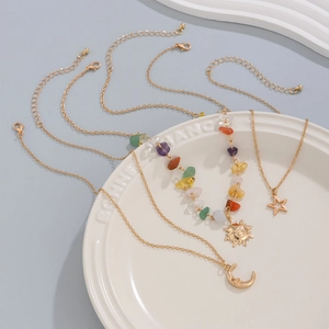 Detailed close-up of retro moon and star necklaces with colored stones on a white ceramic plate