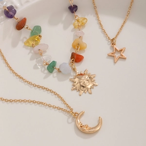 Detailed shot of celestial jewelry set with sun, moon, star pendants and colorful stones