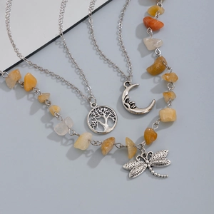 Detailed view of layered silver necklace with tree of life, moon, and dragonfly charms