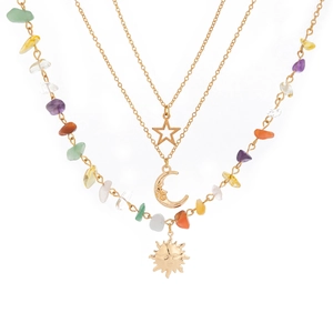 Detailed close-up of bohemian layered necklace with celestial sun moon star charms