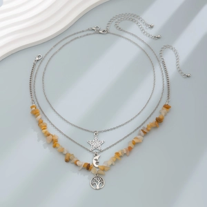 Detail of bohemian layered necklace with moon, star, and stone charms in silver finish