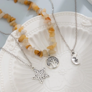 Detail of layered silver necklaces with irregular stones, star and moon smile pendants
