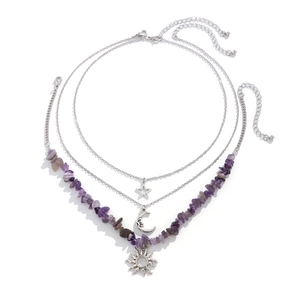 Close-up of triple-layered silver necklace featuring moon, star, and sun pendants with purple stones