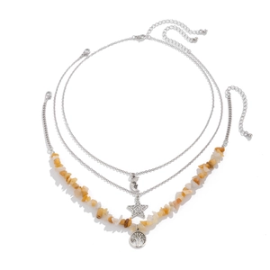 Detailed view of bohemian layered necklace with crescent moon and tree of life pendants
