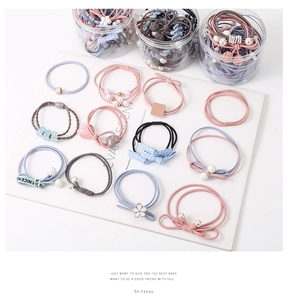Close-up of assorted elastic hair ties with pearls and bows in clear storage jars