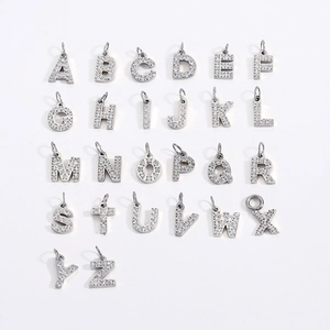 Macro detail of 26 silver alphabet pendants with micro-pave cubic zirconia crystals