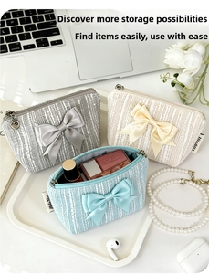 Detail of tweed mini makeup pouches with large satin bows and internal cosmetic storage