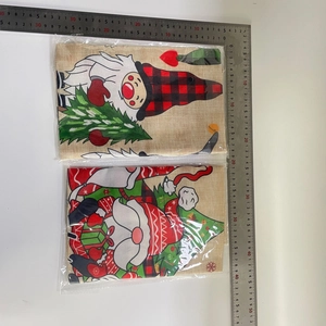Close-up of burlap Christmas gnome garden flags with sizing ruler and clear packaging