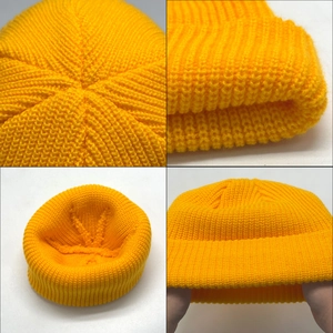 Detail view of bright yellow ribbed knit beanie showing texture and inner structure