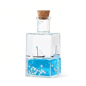 Ocean-themed square glass drift bottle with blue fluid, white boat and star glitter