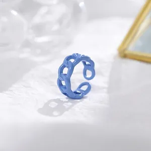 Macro detail of a light blue enamel chain ring with an adjustable open band design