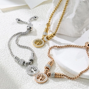 Detailed view of tree of life charm bracelets with cubic zirconia in three metal tones