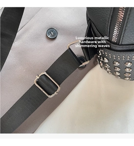 Detail of black leather backpack with silver studs and adjustable nylon shoulder strap