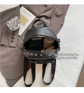 Top-down view of open black rivet backpack showing spacious interior for phone and umbrella