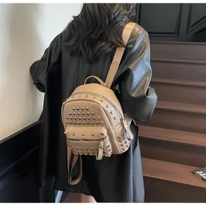 Detail of camel leather backpack with rivet studs and lychee texture on stairs