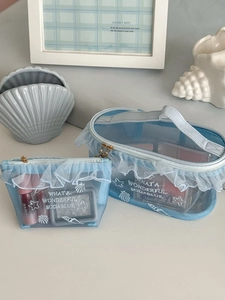 Macro shot of light blue mesh makeup bag set with white lace ruffles and shell embroidery
