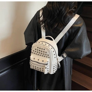 White rivet backpack with litchi texture shown on a model against a dark background