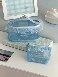 Detail of light blue mesh makeup bag set with white ruffle trim and star embroidery