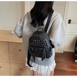 Close-up of black rivet backpack with silver studs and pebbled leather texture