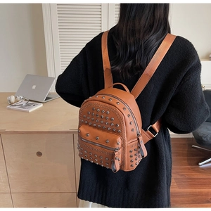 Detail of caramel rivet mini backpack with lychee grain texture and silver studs