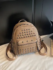 Fashionable beige faux leather backpack with metallic rivets and multi-zipper pockets