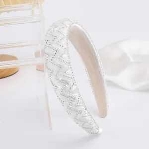 Détail du serre-tête blanc avec paillettes géométriques et perles sur tissu en soie
