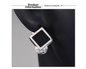 Detail of square black inlay and round clear zircon drop earring on a model
