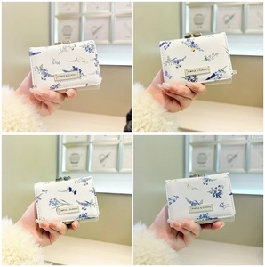 Detail of floral trifold wallet with metallic ball clasp and classic leather label