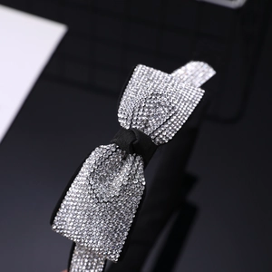 Dettaglio del cerchietto nero con fiocco di strass argentati per un look lussuoso ed elegante