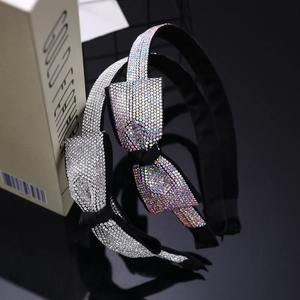 Dettaglio di cerchietti con strass in cristalli argento e iridescenti su fondo nero lucido