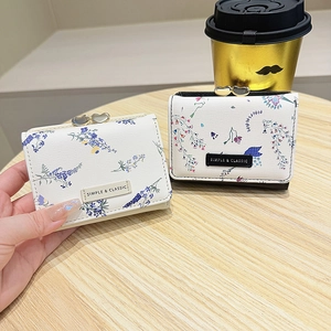 Detail of floral trifold wallets with heart-shaped clasps and vintage leather texture