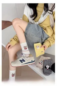 Détail de broderie d'animaux mignons sur des chaussettes en coton côtelé coloré