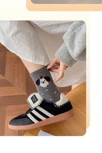 Détail de chaussettes en coton gris avec broderie chien mignonne et pois bleus