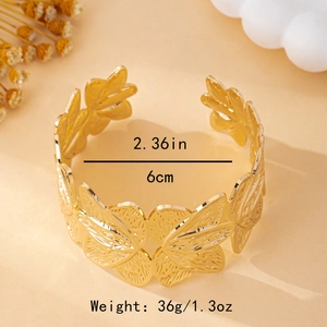 Exaggerated golden wide cuff bracelet with artistic hollow leaf patterns and hammered texture