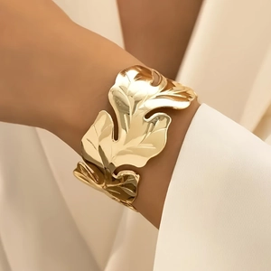 Close-up of a wide gold leaf cuff bracelet with hammer texture on model's wrist