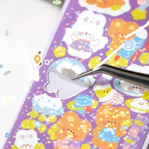 Detail of cute laser glitter stickers featuring rabbit and bear shapes for DIY journaling