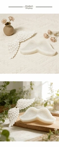 Close-up of translucent silicone angel wing molds with detailed white feather texture