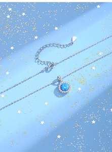 Macro detail of silver necklace with blue opal pendant and adjustable extension chain