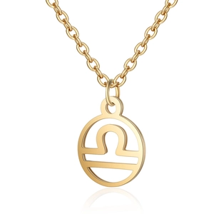 Détail du pendentif doré du signe Balance avec un design géométrique creux raffiné