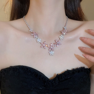 Close-up of elegant flower necklace with pink and clear marquise crystals on neck