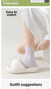 Detail of light purple ribbed cotton socks paired with white platform slippers at home