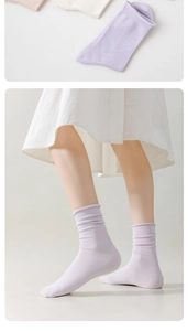 Detail of ribbed knit cotton mid-calf socks in pastel purple, beige and pink tones