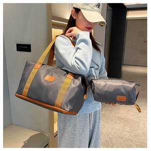 Detail of waterproof nylon travel bag set in dark grey with brown fabric straps