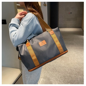 Deep grey travel bag with brown reinforced straps and leather logo detail on grey shoulder