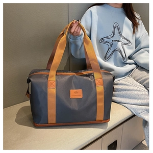 Deep grey large travel bag with brown straps shown in a lifestyle model setting